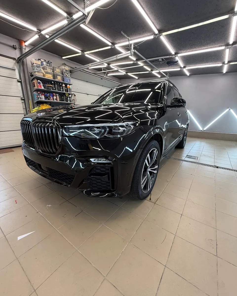 Чёрный BMW X7 G07 в боксе после полной оклейки полиуретановой плёнкой